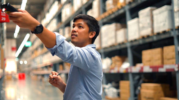 Worker person checking products stock on big shelf in warehouse store. stock photo