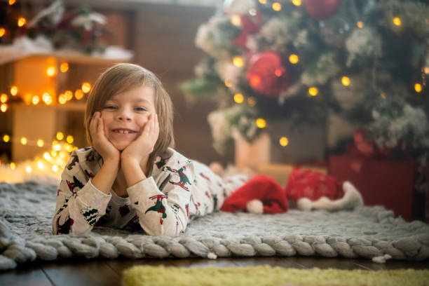 istock Smiling boy on the floor next to Christmas tree 1471917302