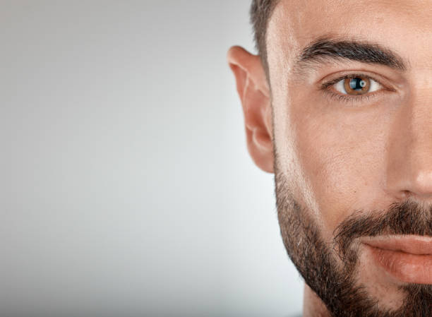 Face, beauty and eye of a man with clean, glow and healthy skin on a grey studio background for dermatology skincare. Portrait of a male with facial cosmetics for self care with marketing free space Face, beauty and eye of a man with clean, glow and healthy skin on a grey studio background for dermatology skincare. Portrait of a male with facial cosmetics for self care with marketing free space piece of mind stock pictures, royalty-free photos & images