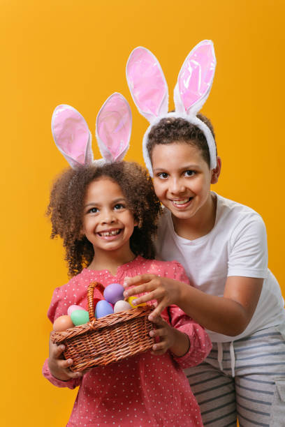 istock A happy children with rabbit ears on her head with a basket full of Easter eggs 1471918401