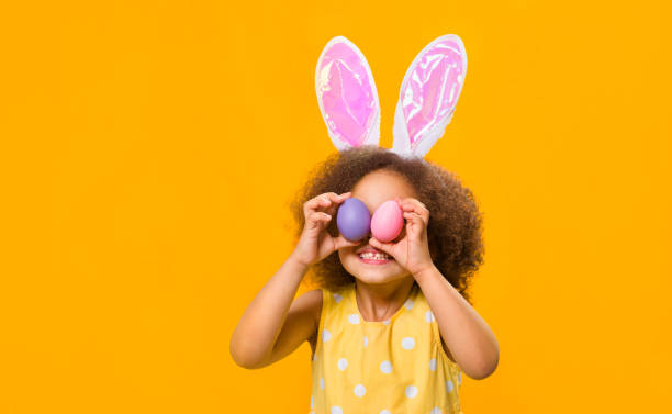 istock A mixed race girl with rabbit ears on her head with painted eggs in her hands 1471918426