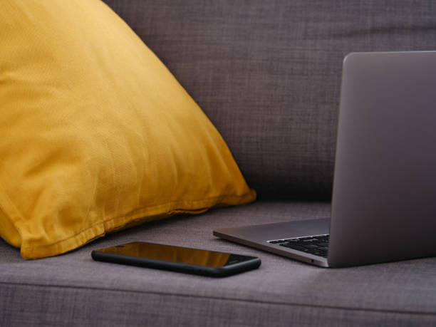 istock A laptop with a smartphone on a gray couch 1471922367