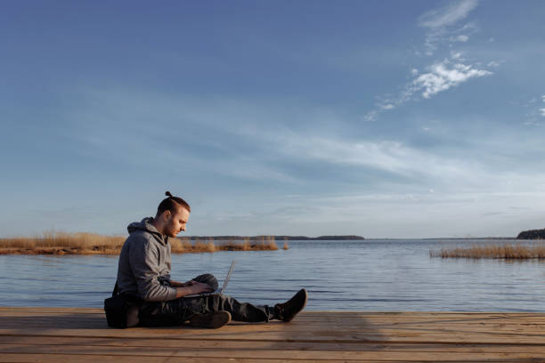 istock Young man working online on laptop outside 1471922398