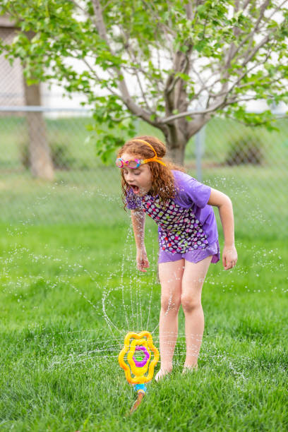 istock Girl Drinking From Back Yard Sprinkler 1471922634