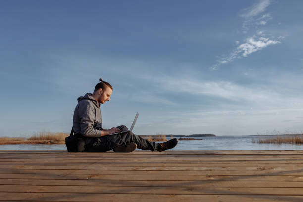 istock Young man working online on laptop outside 1471922991