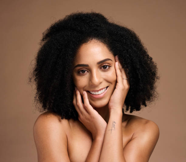 Black woman, portrait and hands with smile, makeup or cosmetic wellness for beauty, face or natural hair. Model, skincare glow and happy, self care or self love with healthy afro by studio background mujer negra, retrato y manos con sonrisa, maquillaje o bienestar cosmético para belleza, rostro o cabello natural. modelo, cuidado de la piel resplandeciente y feliz, cuidado personal o amor propio con afro saludable por fondo de estudio