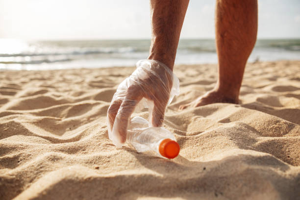 istock Volunteer man collecting trash on the beach. Ecology concept 1471924643