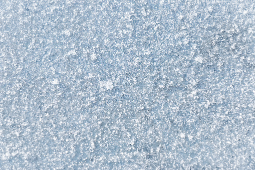 Snow and ice crystals on a metal surface.