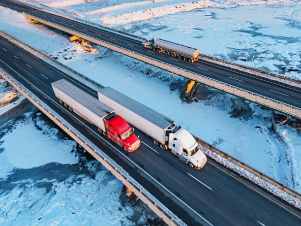 Semi camion che attraversano il fiume ghiacciato - foto stock