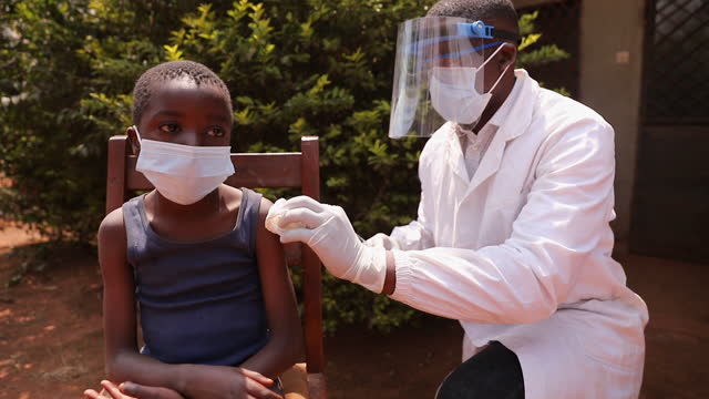 A doctor vaccinates a child at a vaccination center in Africa