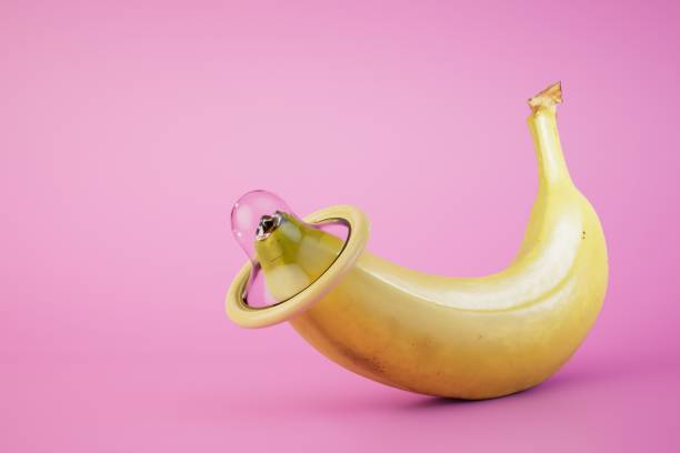 istock a condom worn on the tip of a banana on a pastel background. copy paste, copy space. 3D render 1471929112