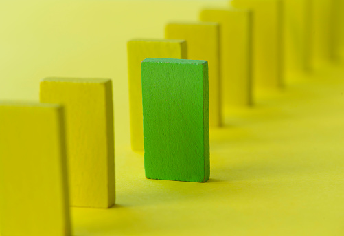 Green cube in line of yellow cubes.