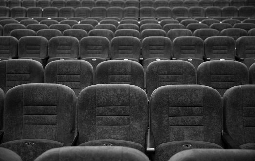 Empty rows of seats in the hall for a large number of people. Cinema and theatre hall for watching performances and movies.