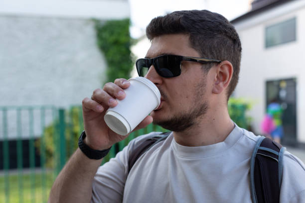istock A man drinks coffee from a paper disposable cup 1471934928