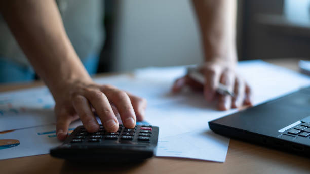 istock Close-up man uses calculator while examining financial reports 1471935586