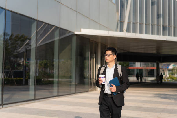 istock Chinese male white collar holding tablet computer on the way to work 1471936466