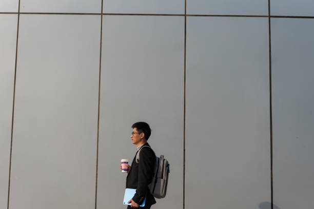 istock Chinese male white collar holding tablet computer on the way to work 1471936819