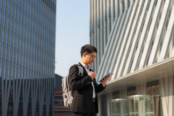 istock Chinese male office worker using tablet outdoors 1471936861