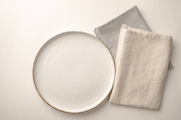 istock Cream-colored plate and linen napkins on a table 1471940304