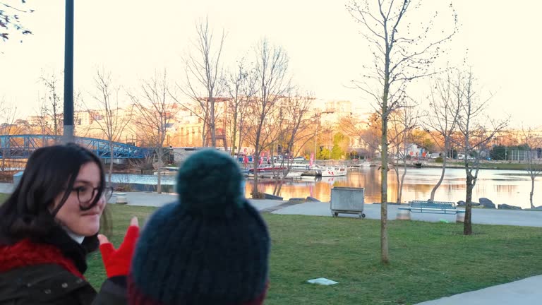 teenager girl and her sister walking in a public park in a cold day