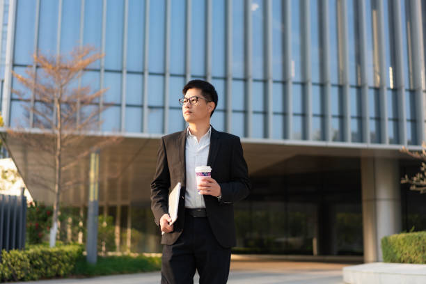 istock Chinese male white collar holding a laptop computer on the way to work 1471942977