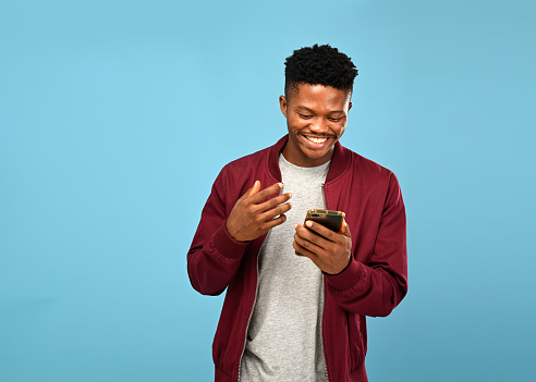 Man Using Mobile Phone İn Blue background studio