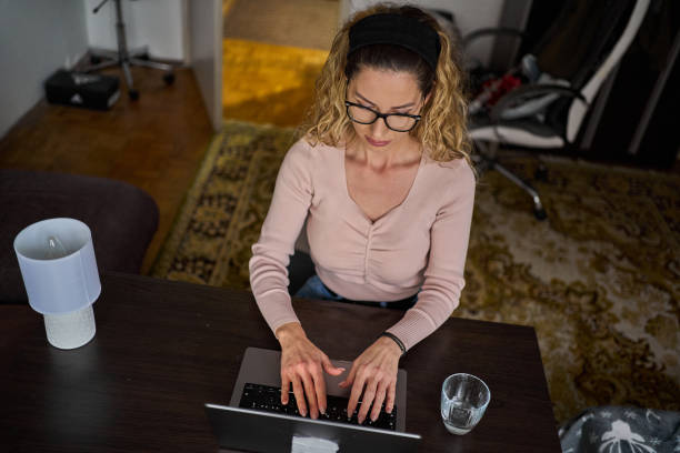 istock Young woman is deep in concentration as she taps away at her keyboard in her quiet workspace 1471946348