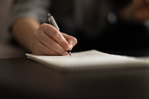 Writing Payroll Check. Hands Signing Cheque Document