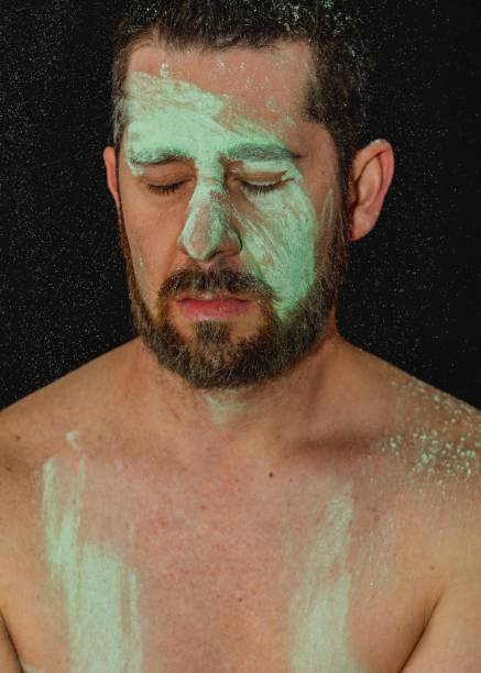 portrait of shirtless man with green body paint across face with beard portrait of shirtless man with green body paint across face with beard nudie suit stock pictures, royalty-free photos & images