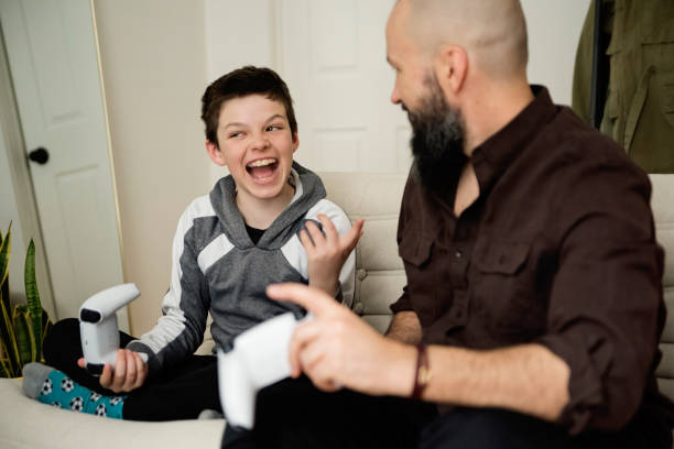 istock Father and son playing video games at home. 1471953013