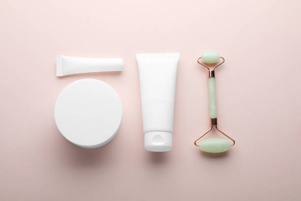 istock Natural face roller and cosmetic products on pink background, flat lay 1471958538
