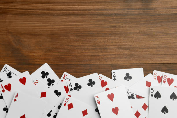 istock Playing cards on wooden table, flat lay. Space for text 1471958795
