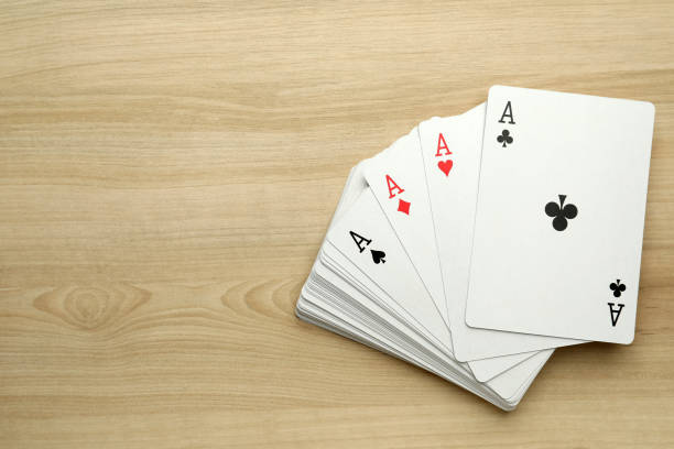 istock Four aces playing cards on wooden table, flat lay. Space for text 1471958848