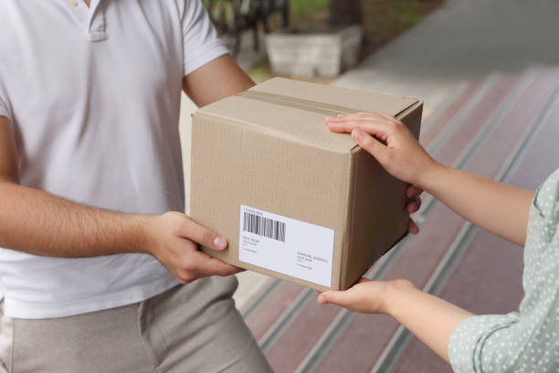 istock Woman receiving parcel from courier outdoors, closeup 1471960001