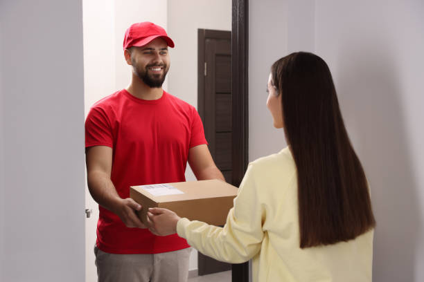 istock Woman receiving parcel from courier at home 1471960080