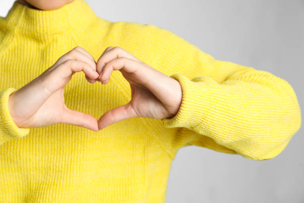 istock Woman making heart with her hands on light grey background, closeup 1471960107