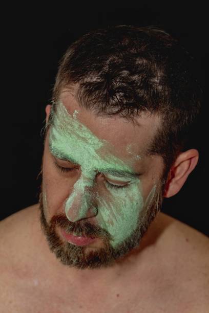 portrait of shirtless man with green body paint across face with beard portrait of shirtless man with green body paint across face with beard nudie suit stock pictures, royalty-free photos & images