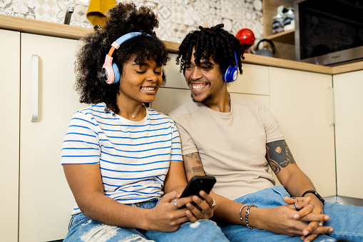 Happy young couple listening to music together