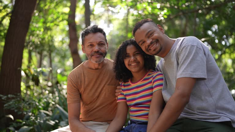 Portrait of a homosexual couple with their daughter in the park