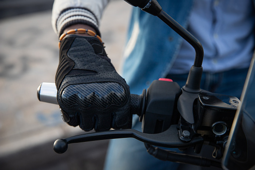 Close-up of an african biker's hand holding the handlebars of his motorcycle.