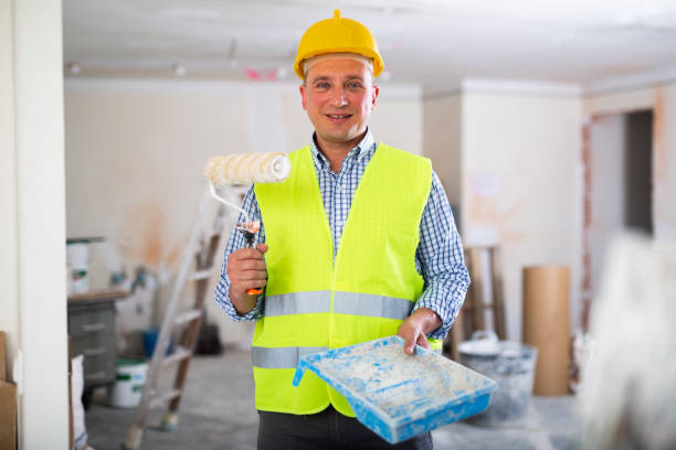 istock Cheerful builder holding paint roller and tray, home improvement works 1471969724