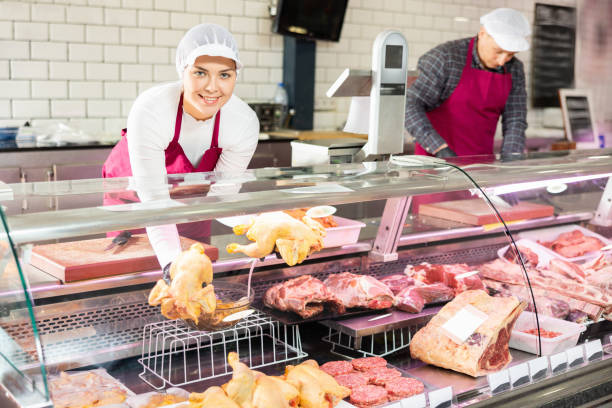 istock Young woman puts chicken meat in showcase 1471970612