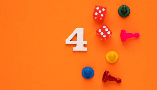 istock Number 4 with dice and board game pieces - Orange eva rubber background 1471973968