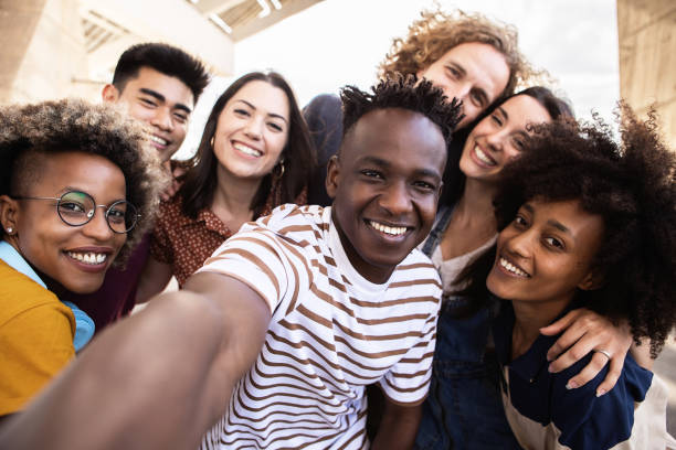 Group of happy young people taking selfie portrait together outdoor stock photo
