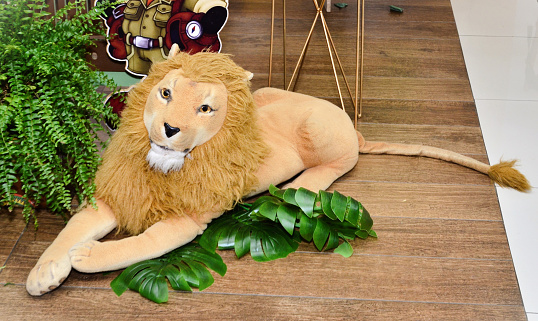 A stuffed lion decorating safari-themed birthday party backdrop