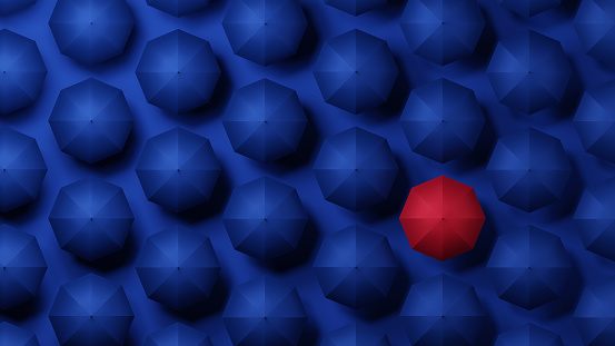 3D Illustration.A red umbrella among blue umbrellas. Images of individuality, leadership, solitude, and originality.
