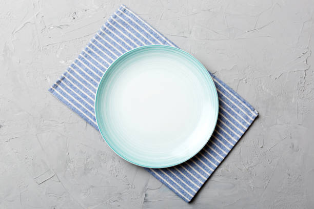 istock Top view on colored background empty round blue plate on tablecloth for food. Empty dish on napkin with space for your design 1471989970
