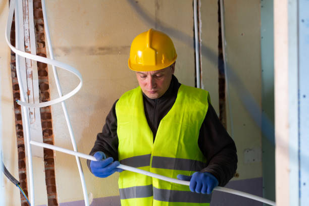 istock Electrician standing with cable duct in hands 1471990758