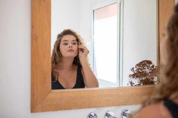 istock Young woman combing her eyebrows in front of the mirror 1471990949