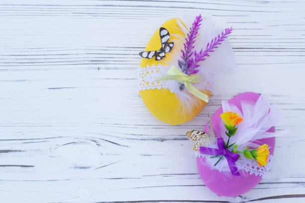 istock Pink and yellow decorated Easter eggs on the wooden table. 1471994111